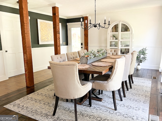 dining room featuring hardwood / wood-style flooring, crown molding, and an inviting chandelier