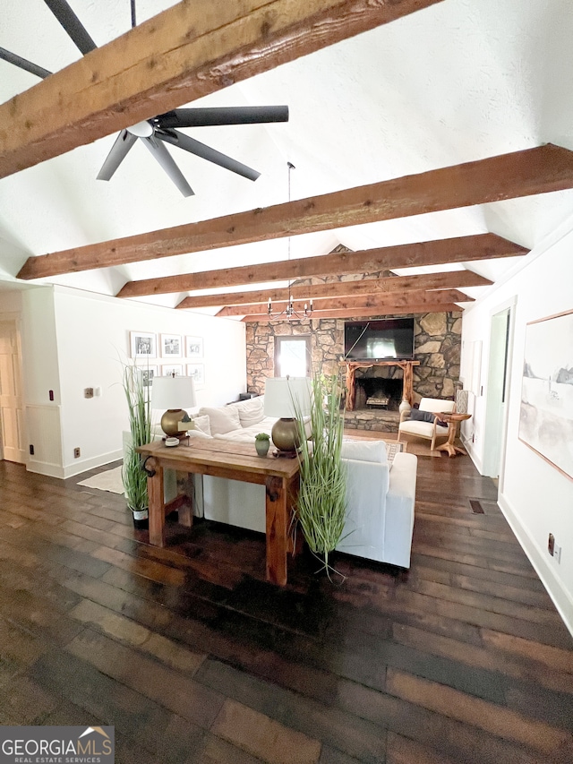 living room featuring vaulted ceiling with beams, ceiling fan, a stone fireplace, and dark hardwood / wood-style floors