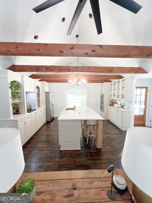 dining area with vaulted ceiling with beams, dark hardwood / wood-style floors, sink, and a chandelier