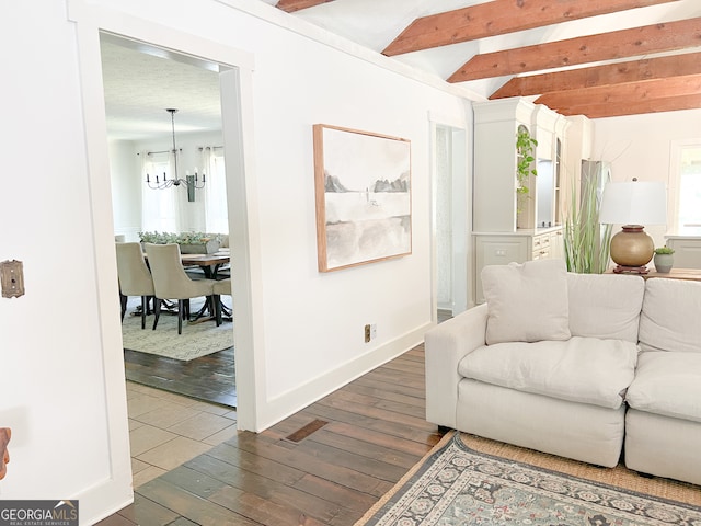 living room featuring beamed ceiling, dark hardwood / wood-style floors, and a notable chandelier