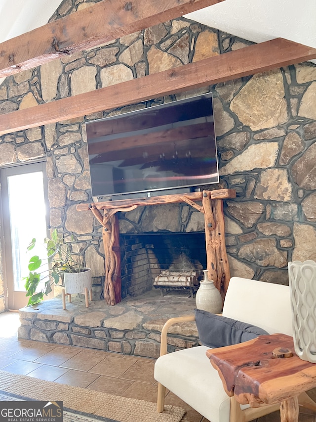 room details with beamed ceiling, tile patterned flooring, and a stone fireplace