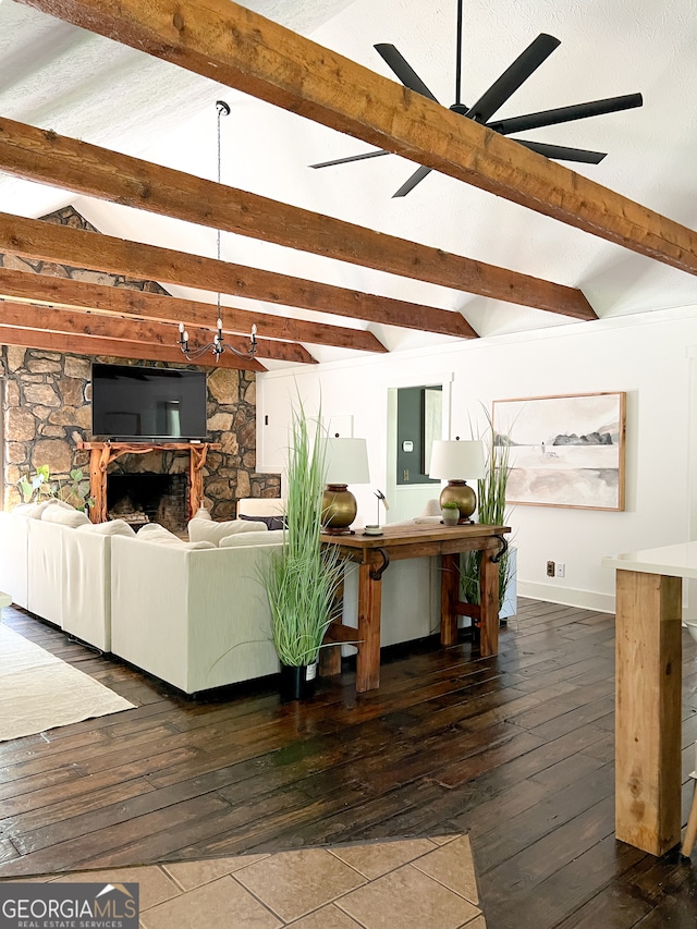 unfurnished living room featuring wood-type flooring, vaulted ceiling with beams, a stone fireplace, and ceiling fan