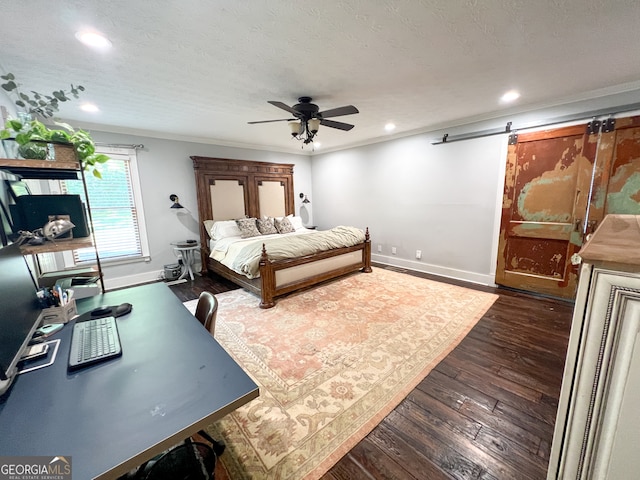 bedroom with dark wood-type flooring, ceiling fan, a barn door, ornamental molding, and a textured ceiling