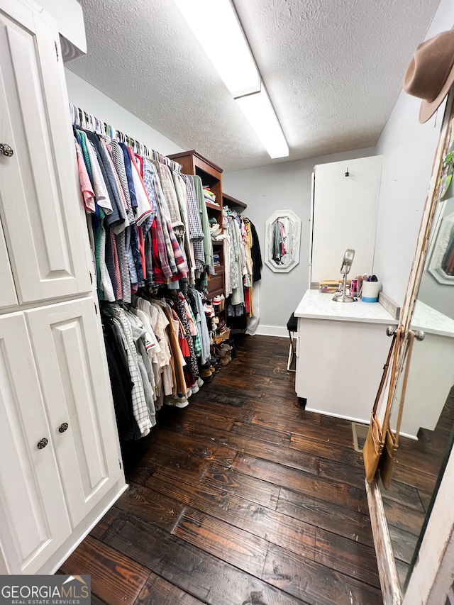 walk in closet with dark wood-type flooring