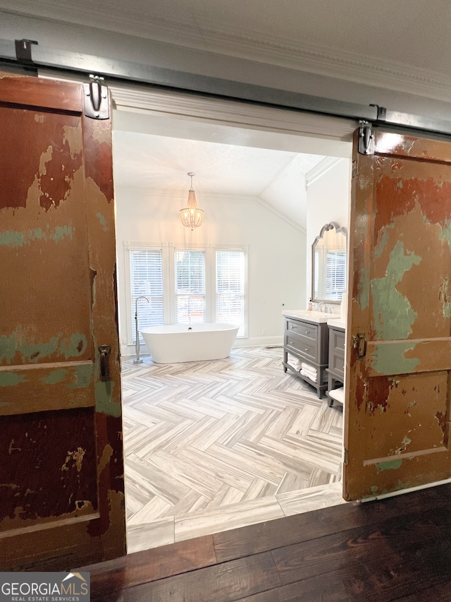 bathroom with lofted ceiling, parquet flooring, a tub to relax in, and ornamental molding