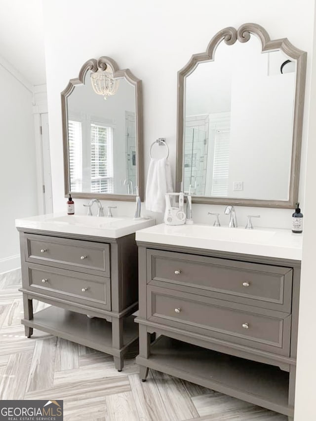 bathroom with parquet floors, vanity, and walk in shower