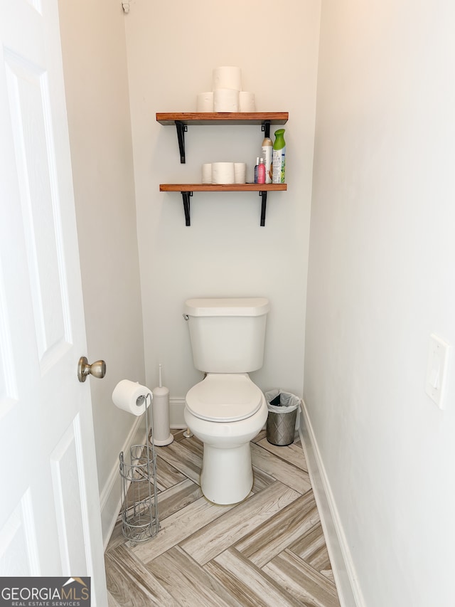 bathroom with hardwood / wood-style floors and toilet