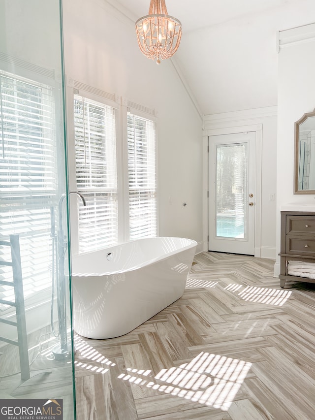 bathroom with a tub, parquet floors, an inviting chandelier, lofted ceiling, and vanity