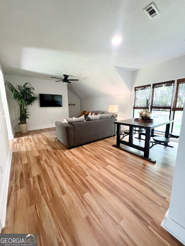 unfurnished living room with ceiling fan, light hardwood / wood-style floors, and lofted ceiling