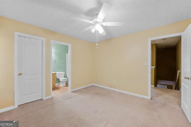 unfurnished bedroom featuring light carpet, ceiling fan, a closet, and a textured ceiling