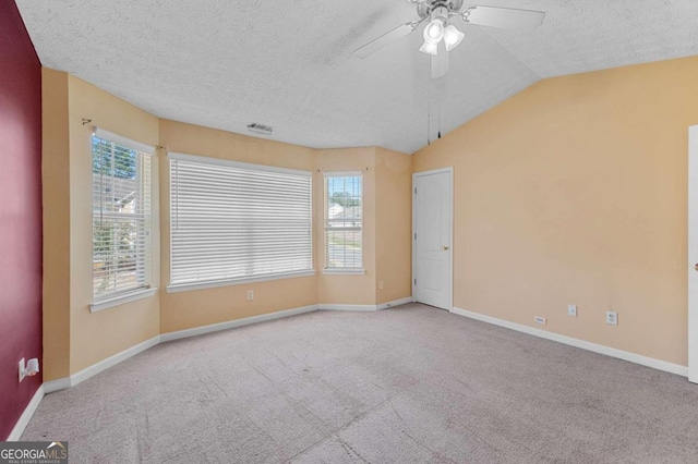 spare room with lofted ceiling, carpet flooring, ceiling fan, and a textured ceiling