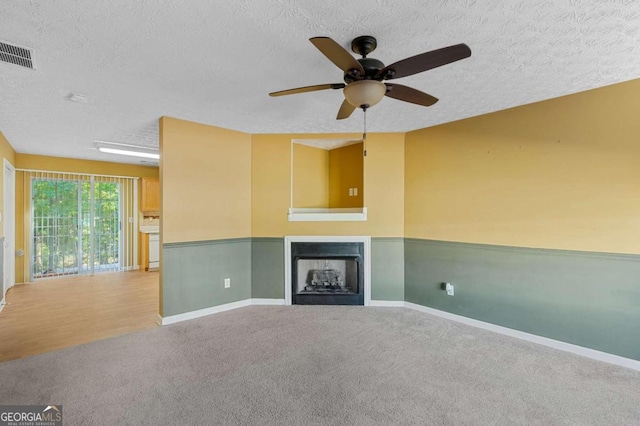 unfurnished living room with wood-type flooring, a textured ceiling, and ceiling fan