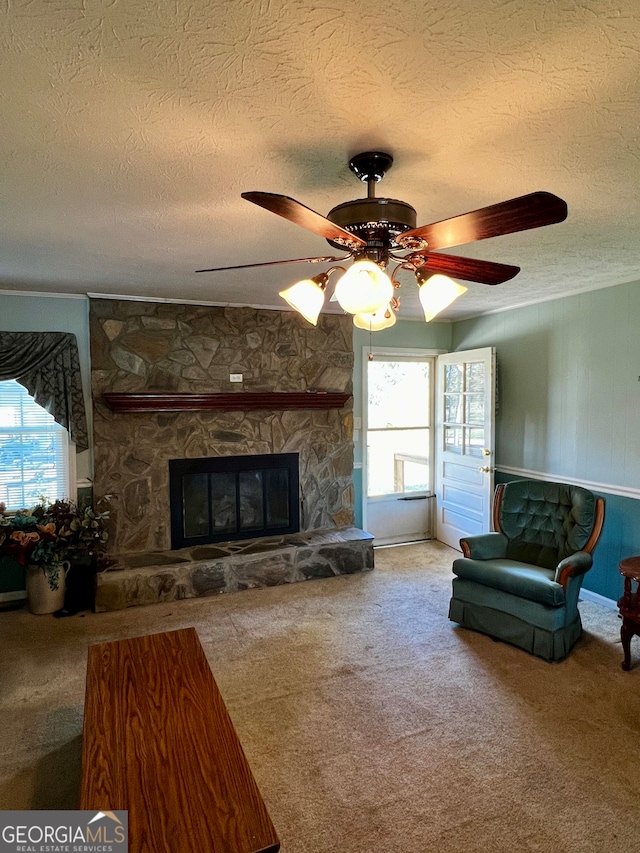 carpeted living room with plenty of natural light, a fireplace, a textured ceiling, and ceiling fan