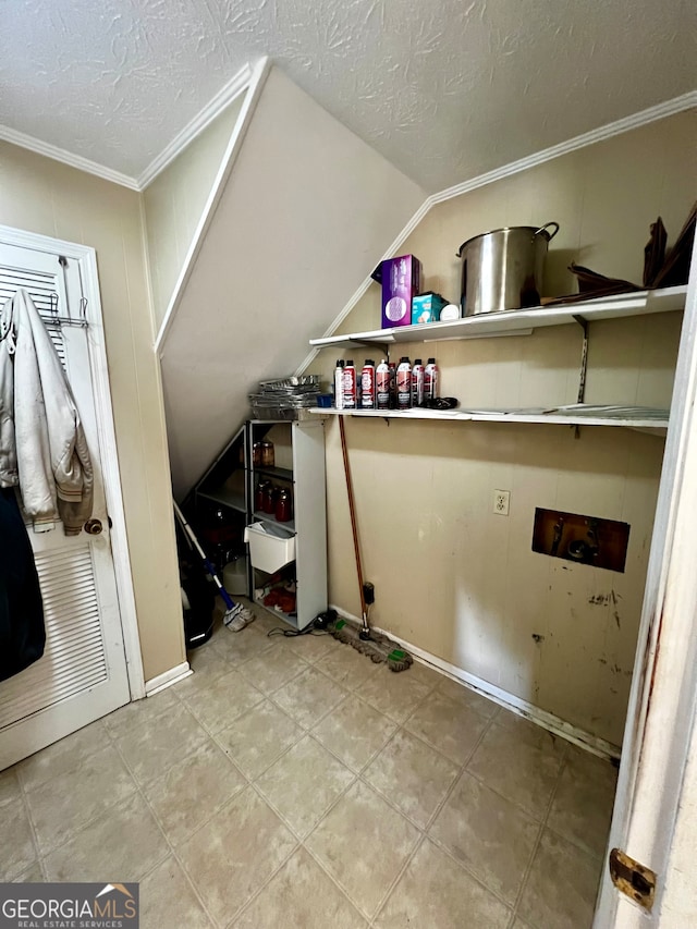 washroom with ornamental molding, a textured ceiling, and hookup for a washing machine