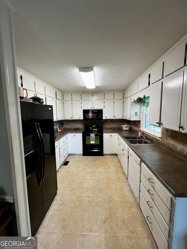 kitchen featuring black appliances, backsplash, white cabinetry, and sink