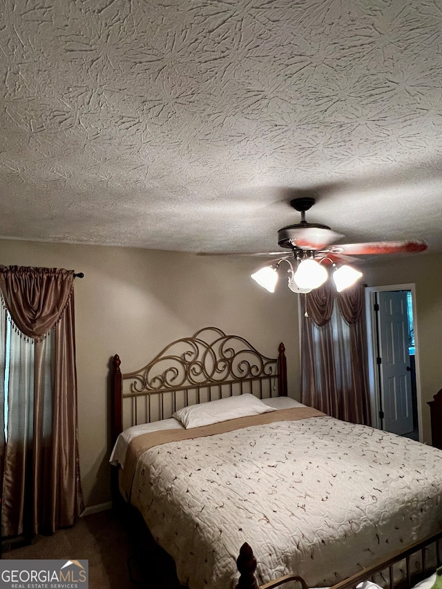 bedroom with carpet, a textured ceiling, and ceiling fan