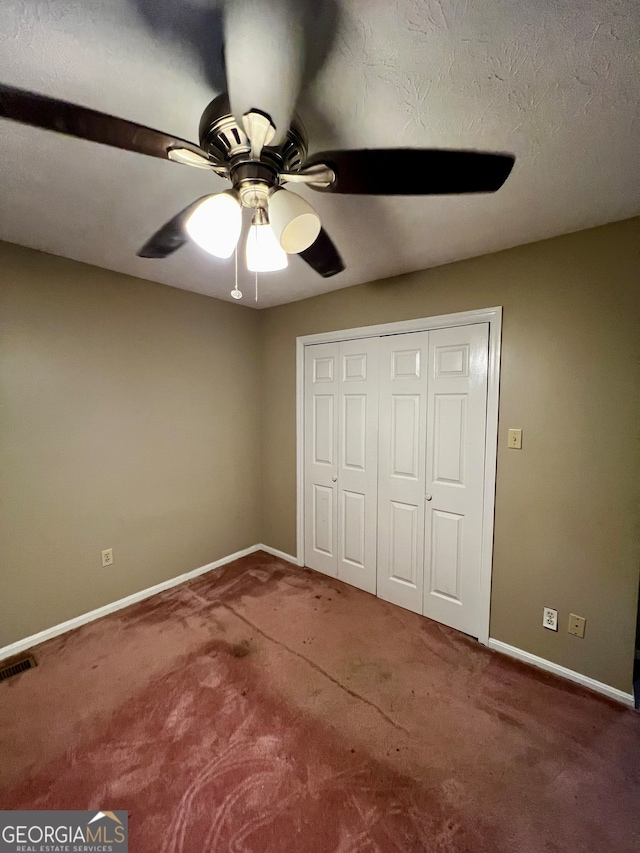 unfurnished bedroom with carpet flooring, ceiling fan, and a closet