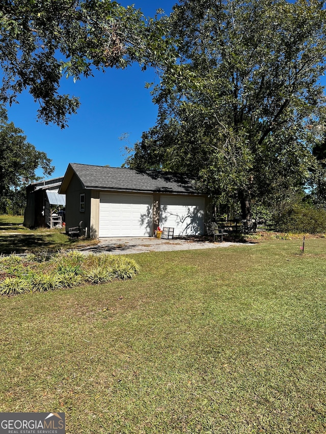 view of front of property featuring a garage, an outdoor structure, and a front lawn