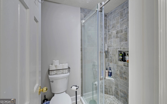 bathroom with an enclosed shower, a textured ceiling, and toilet