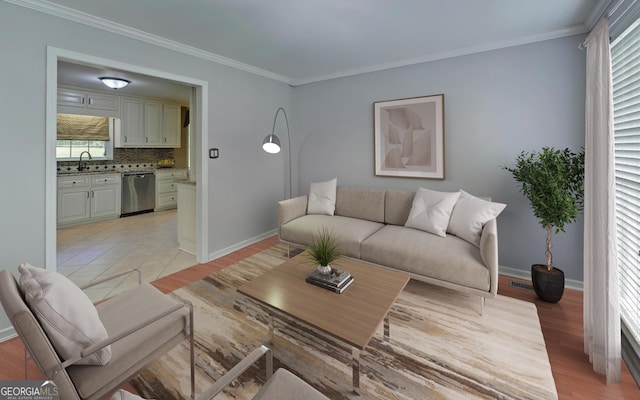 living room featuring crown molding, sink, and light wood-type flooring