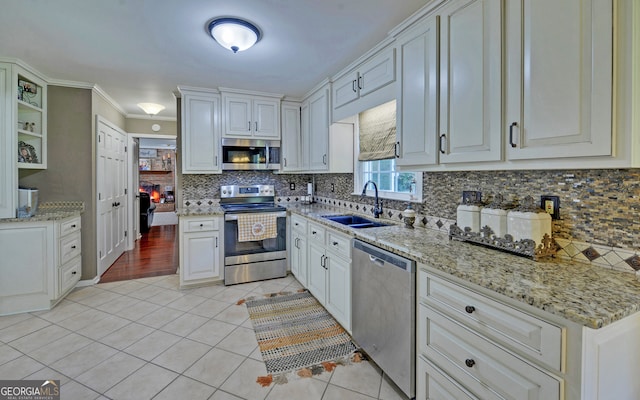 kitchen featuring white cabinetry, appliances with stainless steel finishes, sink, and light tile patterned floors