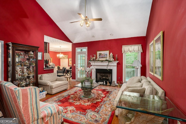 living room featuring high vaulted ceiling, hardwood / wood-style flooring, and ceiling fan with notable chandelier