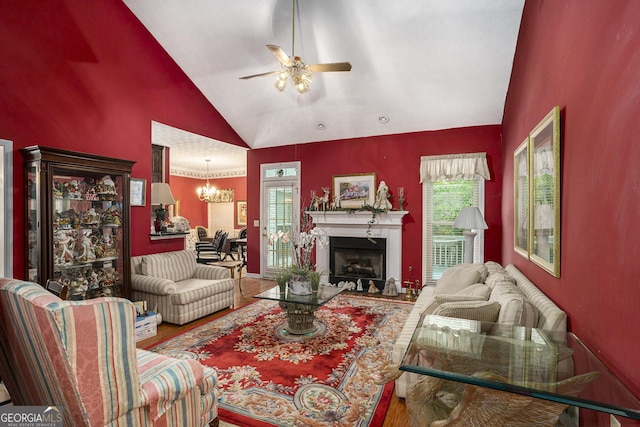 2797 Club Forest Dr, Conyers, GA 30013 - living area featuring a ceiling fan, wood finished floors, a fireplace, high vaulted ceiling, and a chandelier