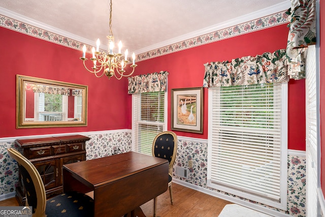 dining space featuring ornamental molding, plenty of natural light, hardwood / wood-style flooring, and a chandelier