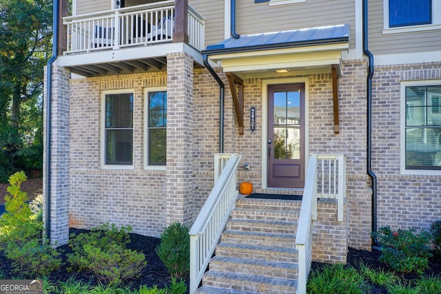 view of exterior entry with a balcony