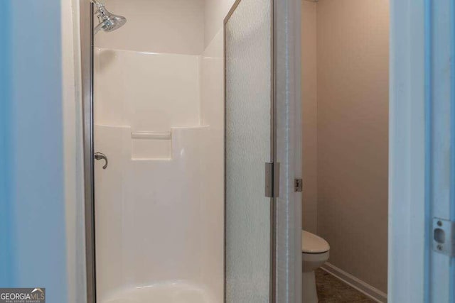 bathroom featuring an enclosed shower and toilet