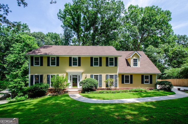 colonial inspired home with a front lawn