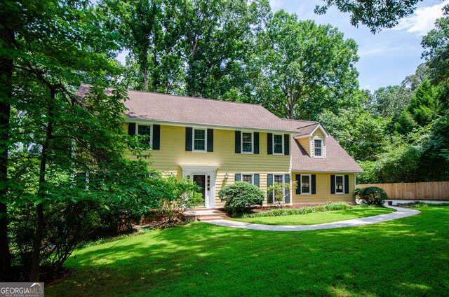 colonial inspired home with a front lawn