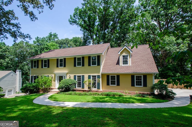 colonial house with a shingled roof and a front lawn