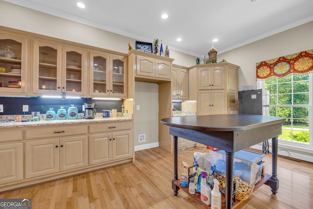 kitchen featuring decorative backsplash, crown molding, light wood-type flooring, and light brown cabinets