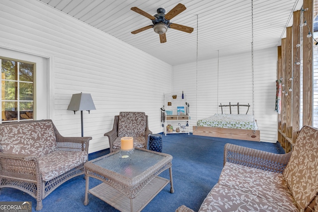 sitting room with ceiling fan, a towering ceiling, and carpet flooring