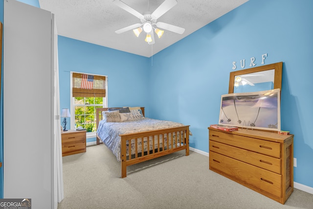 carpeted bedroom with ceiling fan and a textured ceiling