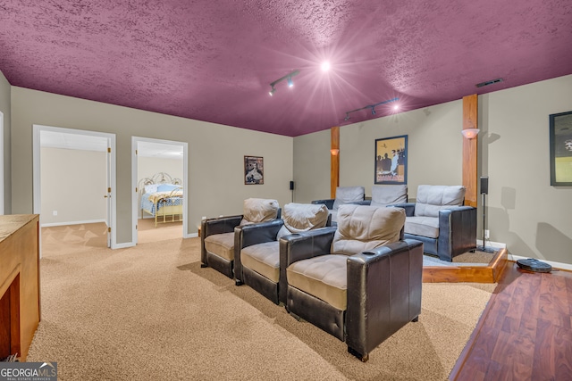 home theater room with light colored carpet and a textured ceiling