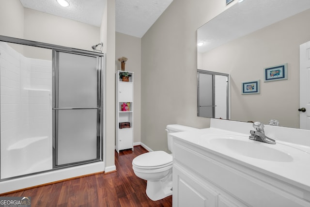 bathroom featuring vanity, walk in shower, toilet, and a textured ceiling