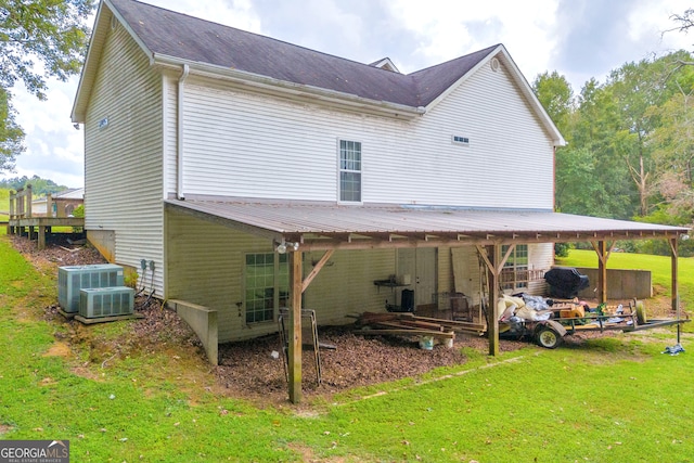 rear view of house with a yard and central AC unit