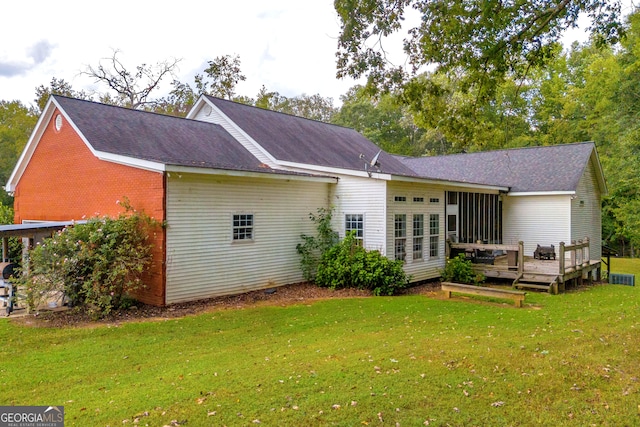 rear view of property featuring a yard and a deck