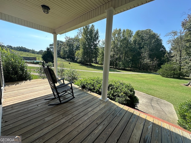 wooden deck featuring a lawn