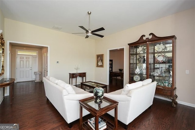 living room featuring ceiling fan and dark wood-type flooring