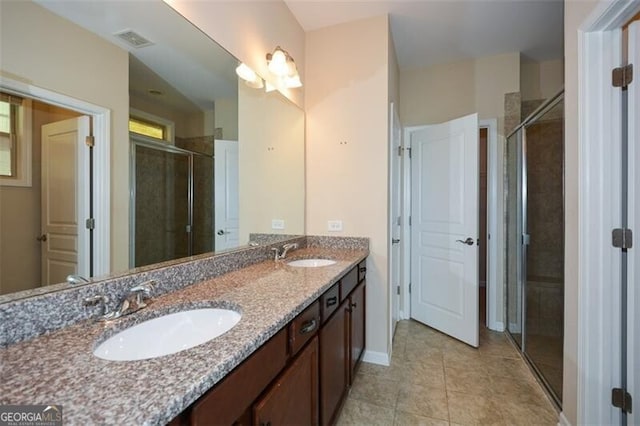 bathroom featuring tile patterned floors, an enclosed shower, and vanity