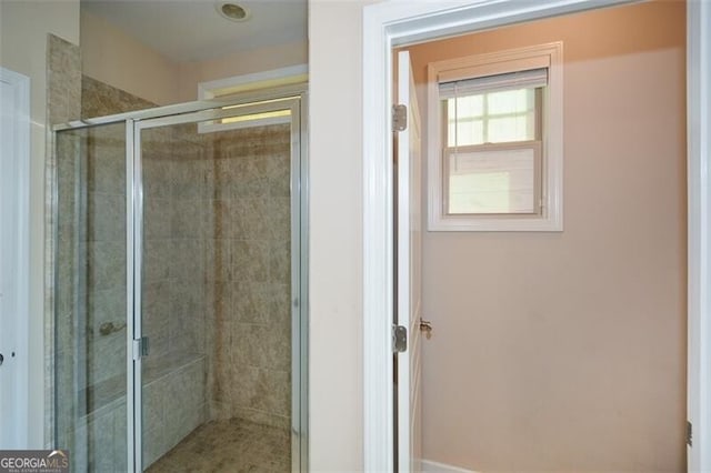 bathroom with a shower with door