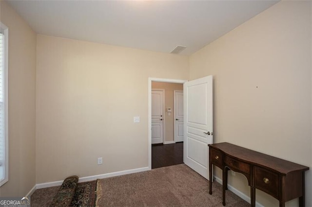 spare room featuring dark colored carpet