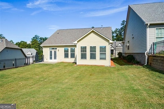 rear view of house featuring a lawn