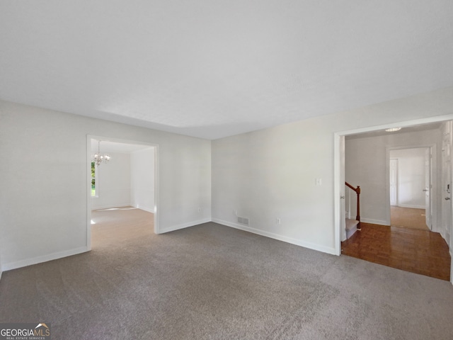 unfurnished room with a notable chandelier and carpet