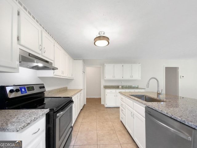 kitchen featuring sink, stainless steel appliances, light stone countertops, white cabinets, and light tile patterned floors