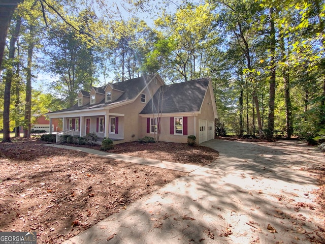 new england style home with covered porch and a garage