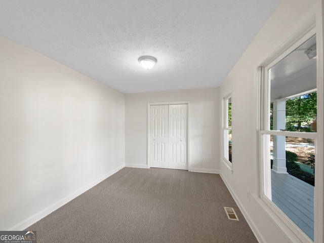 spare room with carpet floors and a textured ceiling